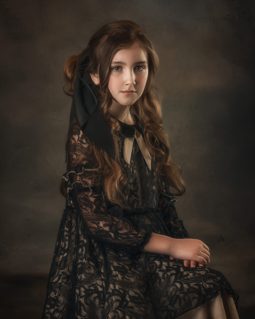 Girl in vintage dress posing with hands in lap