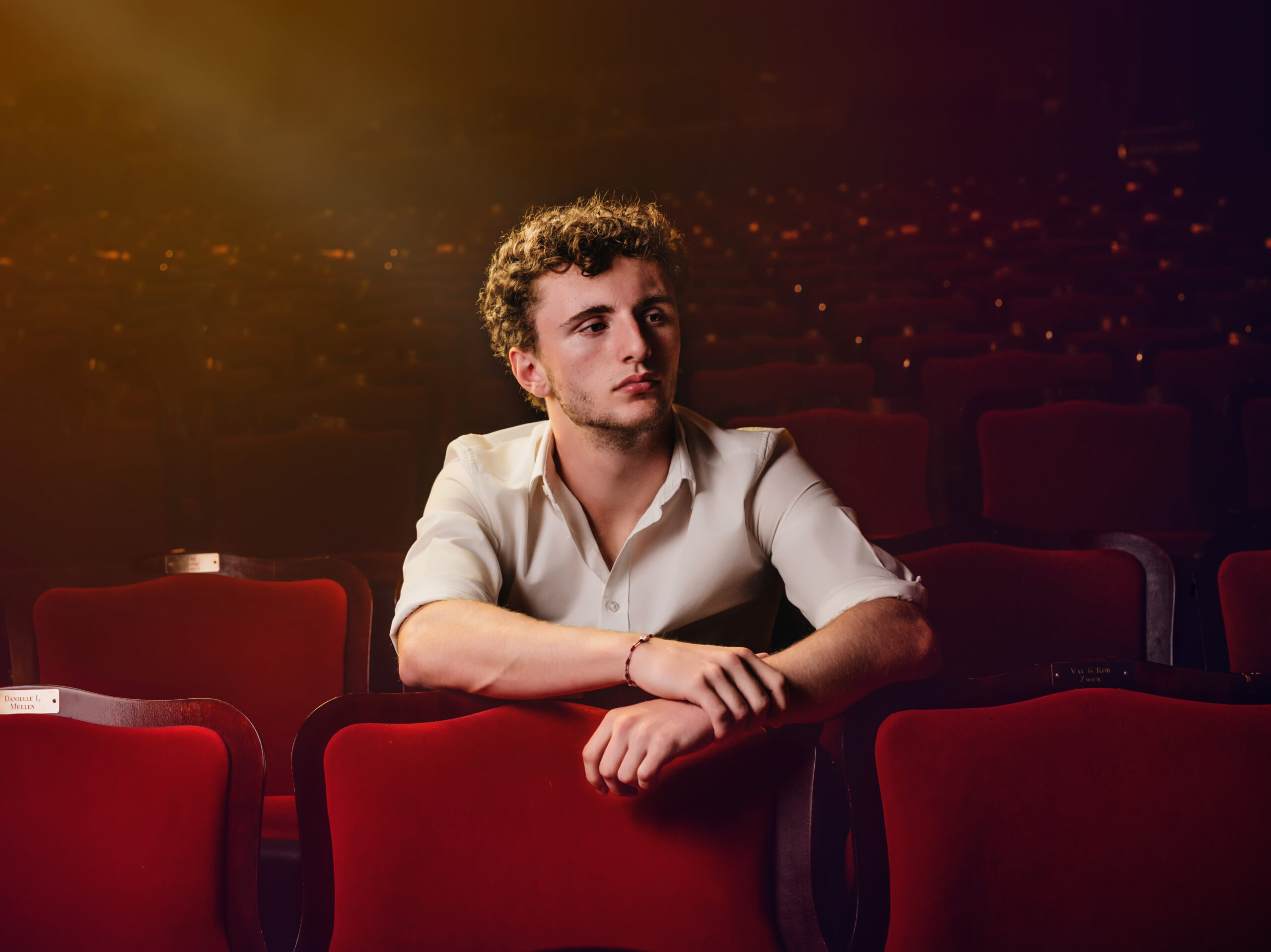 High School Senior sitting in theater seats